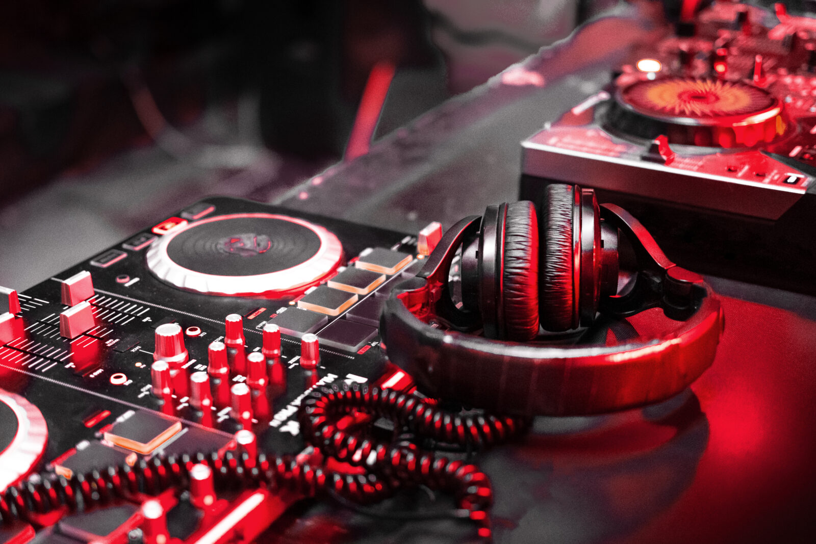 DJ music console in bright colors of light in night club bright background